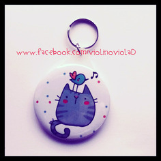 Portachiavi rotondo illustrato. gatto polpetta con uccellino 