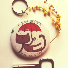 Portachiavi rotondo illustrato. gatto ombrello con frase ottimista 