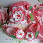 Completino per bebè composto da cappellino e scarpine eseguito a mano all'uncinetto in cotone rosa con fiori applicati 